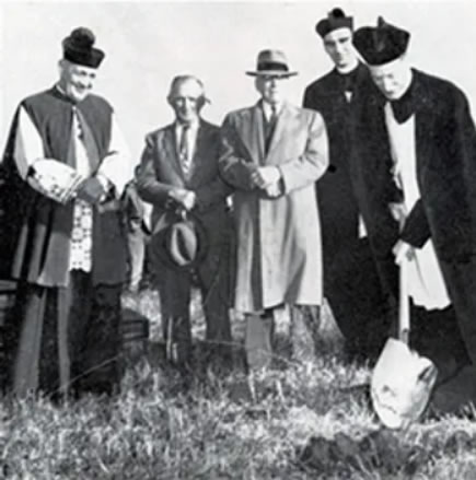 Rev. Herman Ezell, pastor, in foreground as he turned first shovel of dirt at the location of the new parish school. Other (L. to R.): Msgr. Gregory M. Cloos, John Walsh Sr. and Edward Drauden Sr. (Parish Trustees), Rev. Joseph Jurkovich, Assistant at the parish.